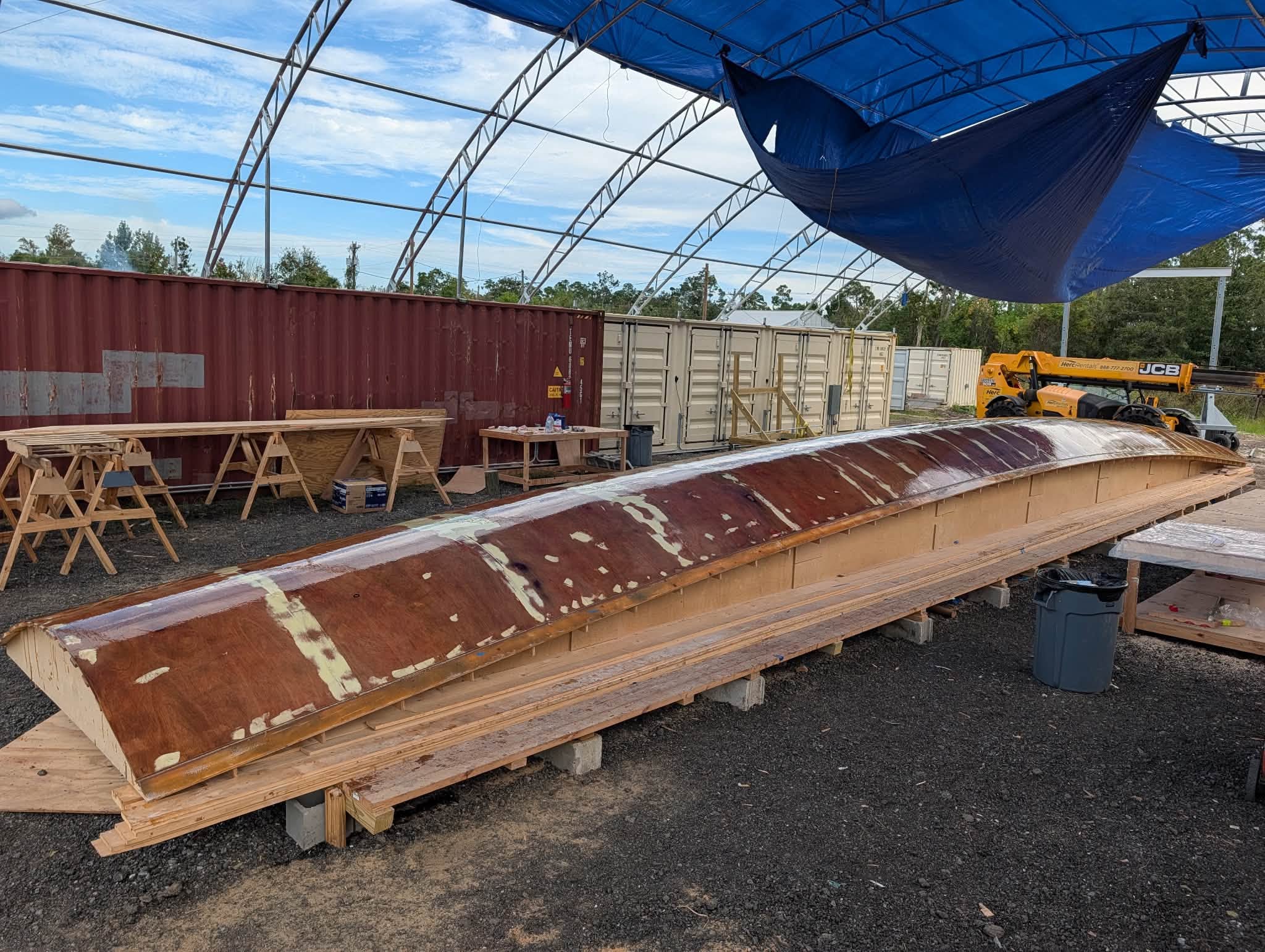 The completed hull mold, glossy and faired, under the tent