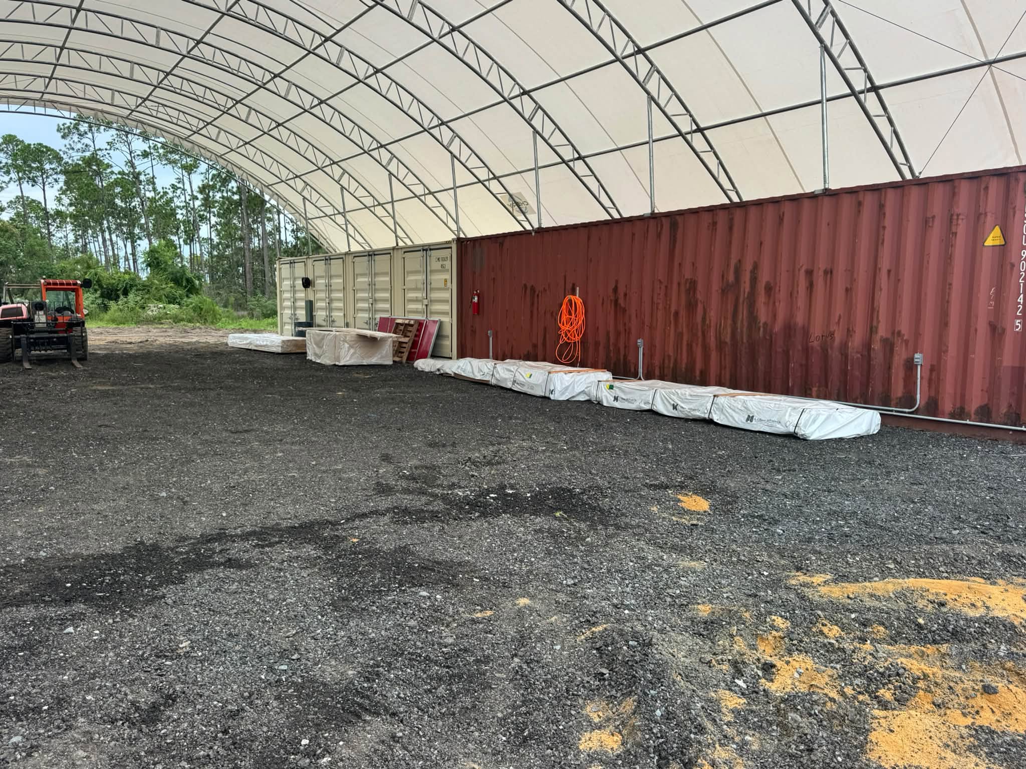The empty tent at the yard with the first bundles of marine plywood delivered
